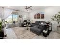 Modern living room featuring a gray sectional sofa, a ceiling fan, and sliding glass doors to a patio at 3670 E Sandoval Dr, San Tan Valley, AZ 85140