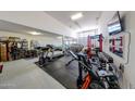 Spacious three-car garage is currently being used as a gym; garage door in back allows for flow-through parking at 3907 S 75Th Dr, Phoenix, AZ 85043