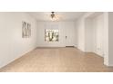 Bright, unfurnished living room featuring tile floors, ceiling fan and front door access at 43142 N Outer Bank Dr, Anthem, AZ 85086