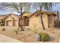 Inviting home exterior with desert landscaping, mature trees, and a well-manicured front yard for a tranquil setting at 5528 W Mine Trl, Phoenix, AZ 85083