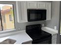 Bright kitchen featuring white cabinetry, quartz countertops, updated appliances, and a window above the sink at 7008 E Gold Dust Ave # 234, Paradise Valley, AZ 85253