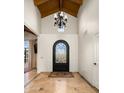 Grand foyer featuring soaring ceilings, a decorative chandelier, and wrought iron front door at 7635 E Sweetwater Ave, Scottsdale, AZ 85260