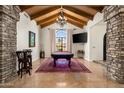 Entertaining game room boasting exposed wood ceilings, a pool table, and a stone accent wall at 7635 E Sweetwater Ave, Scottsdale, AZ 85260