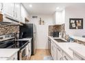 Bright kitchen boasts white cabinetry, stainless steel appliances, and stylish backsplash, creating a modern cooking space at 8055 E Thomas Rd # G101, Scottsdale, AZ 85251
