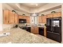 Spacious kitchen featuring custom wood cabinets, granite countertops, and modern black appliances at 8785 E Sandtrap Ct, Gold Canyon, AZ 85118
