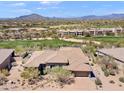 Stunning aerial view of a desert home with a tile roof overlooking lush golf course and mountains at 9620 E Roadrunner Dr, Scottsdale, AZ 85262