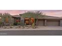 A luxury desert home showcases beautiful stone accents, a tile roof, and a meticulously landscaped front yard at 9620 E Roadrunner Dr, Scottsdale, AZ 85262