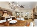 Spacious living area with a dining table, connecting kitchen, hardwood floors, and a ceiling fan at 9858 E South Bend Dr, Scottsdale, AZ 85255