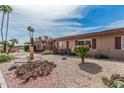 Quaint desert landscape with a decorative eagle statue, native cactus, and palm trees accenting this lovely home at 10855 W Buccaneer Dr, Sun City, AZ 85351