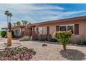 Quaint desert landscape with a decorative eagle statue, native cactus, and palm trees accenting this lovely home at 10855 W Buccaneer Dr, Sun City, AZ 85351