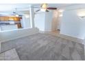 Open-concept living area with tile flooring, carpet, ceiling fan, and kitchen access at 1366 E Desert Fern Trl, Casa Grande, AZ 85122
