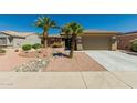 Charming home featuring desert landscaping with gravel and rock accents, and mature palm trees at 15136 W Cactus Ridge Way, Surprise, AZ 85374