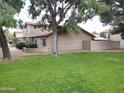 Inviting exterior of the townhome featuring lush green lawn and mature shade trees at 17620 N 17Th Pl # 36, Phoenix, AZ 85022