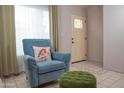 Cozy sitting area with comfortable blue chair, footstool, and sunlit window at 17620 N 17Th Pl # 36, Phoenix, AZ 85022