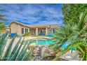 Tranquil backyard oasis with a pristine pool, lush landscaping, and comfortable lounge furniture at 1893 W Canary Way, Chandler, AZ 85286