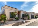 Charming single-story home with desert landscaping and a modern garage door under a blue sky at 21 W Beryl Ave, Phoenix, AZ 85021
