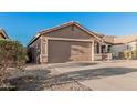 Well-kept single-story home showcasing a two-car garage and tidy desert landscaping at 2738 E Silversmith Trl, San Tan Valley, AZ 85143