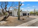 Stylish modern home with desert landscaping and two-car garage, under a partly cloudy sky at 28341 N 112Th Way, Scottsdale, AZ 85262