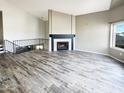 Spacious living room with wood-look tile, a fireplace, a staircase and bright windows at 3134 E Mckellips Rd # 50, Mesa, AZ 85213
