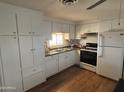 Well-lit kitchen featuring white cabinets, modern appliances, and wood-style floors that offer great functionality and style at 4065 E University Dr # 88, Mesa, AZ 85205