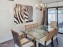 Dining room features a glass-top table, woven chairs, and a modern chandelier at 5601 E Monte Cristo Ave, Scottsdale, AZ 85254