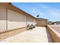 A serene backyard featuring a low brick wall, mature plants, and an outdoor patio for entertaining at 7310 E Dewberry Ave, Mesa, AZ 85208