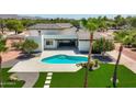 Beautiful backyard with pool, sleek patio, lush green grass, and desert landscaping at 10620 N 84Th St, Scottsdale, AZ 85260