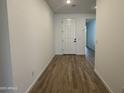 An inviting entryway with light walls, wood-look tile flooring, and a bright white front door at 15786 W Cheryl Dr, Waddell, AZ 85355