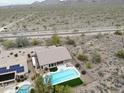 Aerial view of the property featuring a sparkling pool, lush landscaping, and mountain views at 10423 E Verbena Ln, Scottsdale, AZ 85255