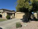Single Gathering home featuring desert landscaping, well-maintained lawn and an attached two-car garage at 11570 W Pima St, Avondale, AZ 85323