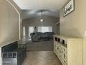 Inviting living room featuring a vaulted ceiling, carpet flooring and comfortable seating, creating a warm, welcome ambiance at 11570 W Pima St, Avondale, AZ 85323