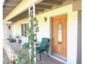 Inviting front porch featuring a beautiful wood door, seating area, and decorative plants at 1257 E Dartmouth St, Mesa, AZ 85203