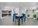 Stylish dining area adjacent to the kitchen, featuring blue chairs and decorative plants at 14521 W Gelding Dr, Surprise, AZ 85379
