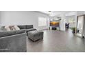 Comfortable living room with gray sectional, modern TV, and abundant natural light at 14521 W Gelding Dr, Surprise, AZ 85379
