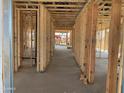 Interior framing reveals home's layout with wood studs, concrete flooring, and pre-wired utilities at 15777 W Cheryl Dr, Waddell, AZ 85355