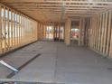Interior framing showing a spacious room with concrete flooring and wood frame construction at 15777 W Cheryl Dr, Waddell, AZ 85355