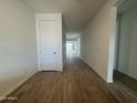 Bright hallway with wood-look flooring and white walls and a bright light at the end at 15777 W Cheryl Dr, Waddell, AZ 85355