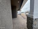 Covered porch with brick pillars and stone-paved walkway leading to the front door at 15777 W Cheryl Dr, Waddell, AZ 85355