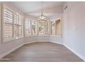 Cozy dining area featuring contemporary floors, plantation shutters and a stylish pendant light at 20449 N 105Th Ave, Peoria, AZ 85382