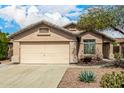 Home exterior featuring desert landscaping, a two-car garage, and neutral paint at 23006 W Cantilever St, Buckeye, AZ 85326