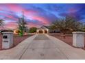 Long driveway leading to a desert home with an oversized garage and meticulously maintained landscaping at 23040 W Hammond Ln, Buckeye, AZ 85326