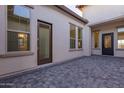 Charming courtyard with paver flooring, offering a private outdoor living space and multiple entry points to the home at 2636 E Virginia St, Mesa, AZ 85213