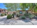 Single-story home with a well-maintained yard featuring lush landscaping and mature trees at 271 W Key West W Dr, Casa Grande, AZ 85122