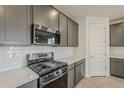 Close-up of a modern kitchen with stainless steel gas range, microwave, and subway tile backsplash at 40030 W Bunker Dr, Maricopa, AZ 85138