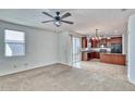 Open-concept living room with carpet flooring flowing seamlessly into the kitchen and access to the back patio at 4252 E Vest Ave, Gilbert, AZ 85295