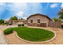 Well maintained front yard exhibiting circular green grass with surrounding desert landscaping at 4255 S Marisol Ln, Gilbert, AZ 85297