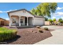 Charming single-story home boasts a covered porch, desert landscaping, and an attached two-car garage at 4606 S Marron --, Mesa, AZ 85212