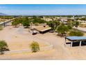 View of the front of this property with a long overhang and gravel drive; red car parked in front at 51089 W Julie Ln, Maricopa, AZ 85139