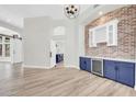 Open-concept dining area features tiled floors, brick accent wall, and a bar area with a wine cooler at 6041 E Hartford Ave, Scottsdale, AZ 85254