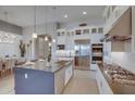 Stylish kitchen with a large island, stainless steel appliances, gas cooktop and bright, open layout at 6091 N Sunrise Ln, Buckeye, AZ 85396